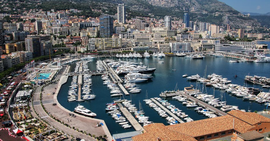 Overview of Port Hercule, looking over many motor yachts and sailing boats moored in the marina.