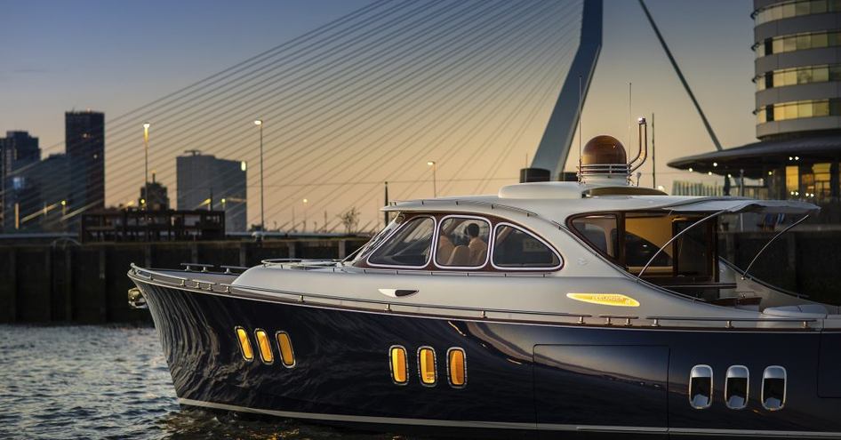 Dark blue Zeelander Z55 yacht underway heading towards a bridge and high rise buildings