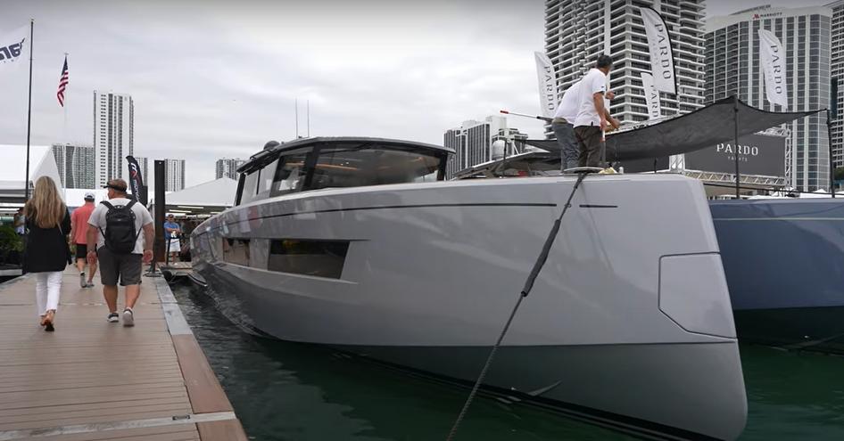 Pardo Yachts on display at Miami International Boat Show, with adjacent pontoon and visitors walking between displays.