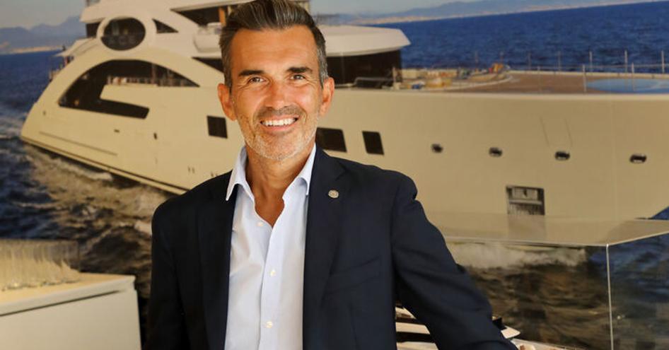 Portrait of Raphael Sauleau, CEO of IYC, with image of a superyacht in the background.