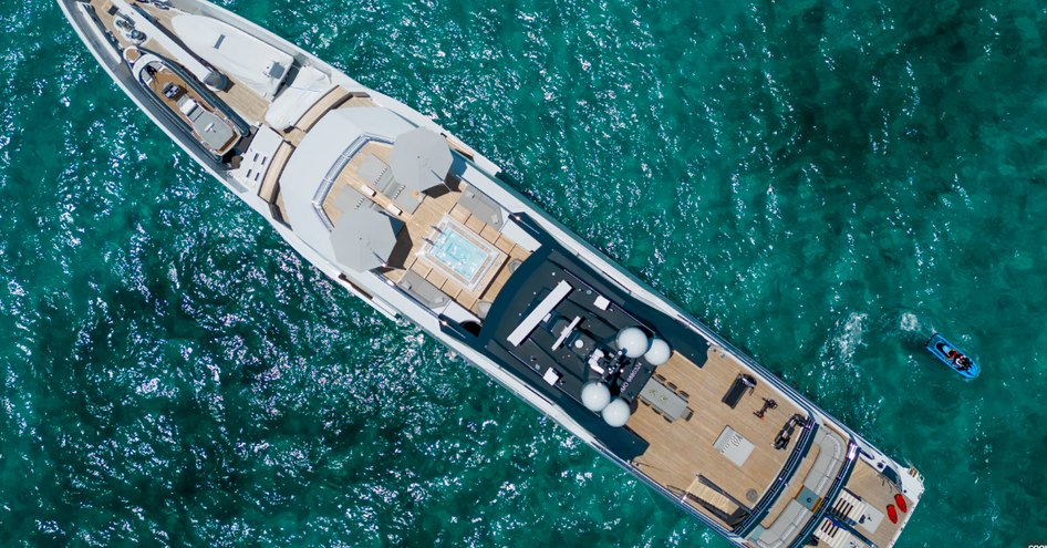 Aerial, bird's eye view, of superyacht ENTOURAGE at sea. Exterior decks visible surrounded by sea.