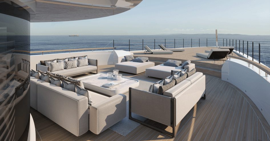 Lounge area on the bow of Project Rinascimento, seating arrangement of three sofas facing each other with central coffee table, surrounded by sea in background