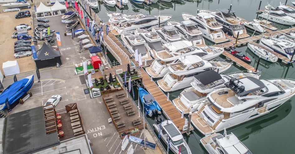 Elevated view of Swanwick marina setting up for British Motor Yacht Show. Multiple motor yachts berthed alongside dock.