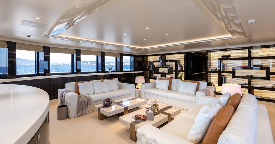 Overview of the main salon onboard superyacht SOARING. White sofas facing in to each other around low down coffee tables.