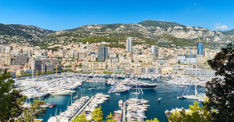 Overview of Monaco Yacht Show, many motor yachts moored in Port Hercule.