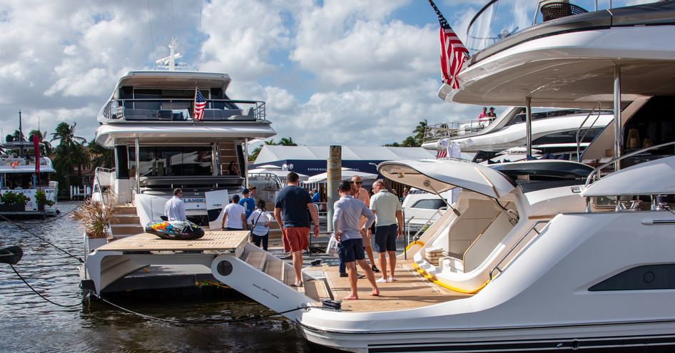 A group of people standing on the stern of a superyacht berthed at the Fort Lauderdale International Boat Show