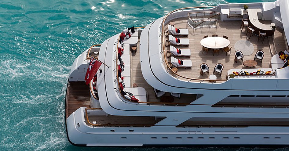 Overview of the Feadship superyacht FLAG aft decks, exterior seating areas visible on each deck, surrounded by sea.