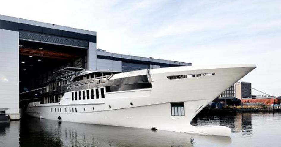 white Heesen superyacht Project Castor cruises out of the shipyards covered facility on the day of its launch