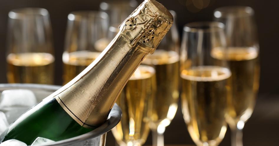 A champagne bucket with filled glasses in the background