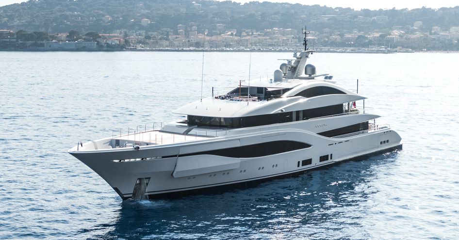 Front angle view of M/Y ARROW at anchor in a bay, with land in far distance.