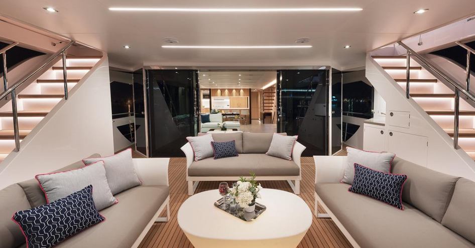 three sofas face a low white table to form a seating area on the main deck aft of the FD87 Skyline