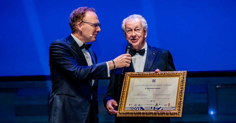 Kommer Damen on stage holding award for Lifetime Achievement at Maritime Awards Gala.