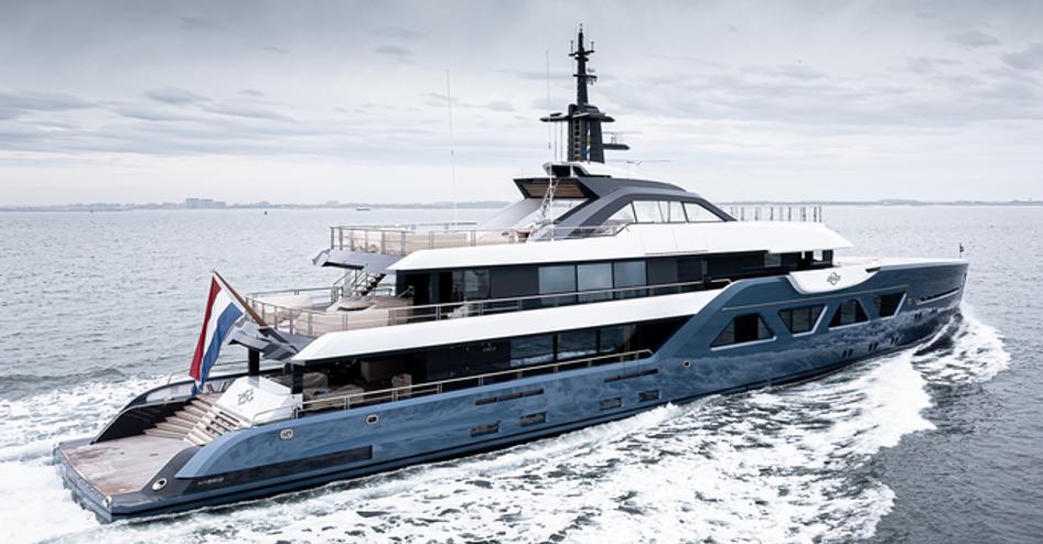 The Amels 60 superyacht 21.12 showing its starboard-side, running through a clam grey sea