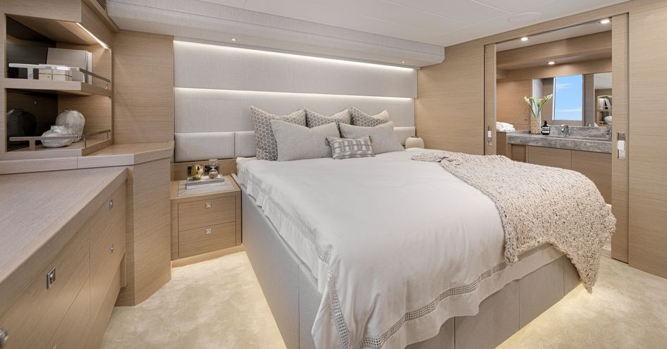 Master cabin onboard the Horizon V74, central berth with shelving to port side and a large mirror to starboard.