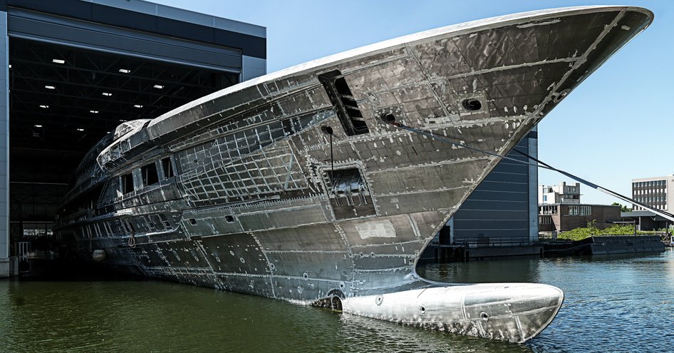 Hull of yacht emerging from outfitting shed