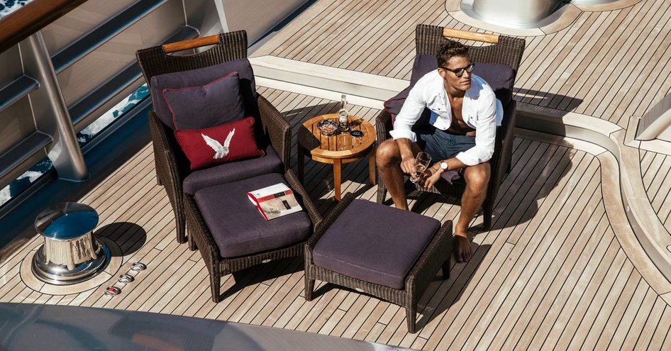 Man sitting down on sun chair aboard a superyacht