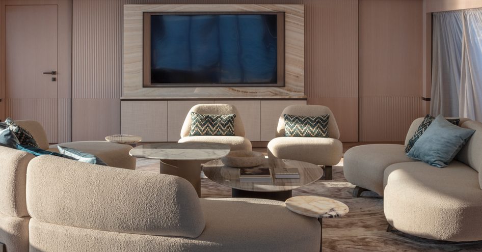 The salon aboard superyacht FRETTE uses comfortable furnishings and warm tones to deliver a relaxing atmopshere