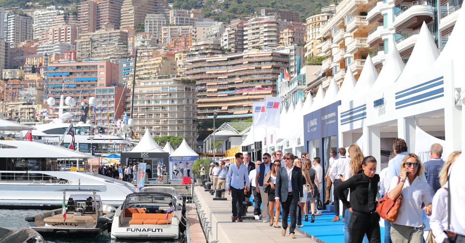 Exhibitor stands at MYS, visitors walking along boardwalk.