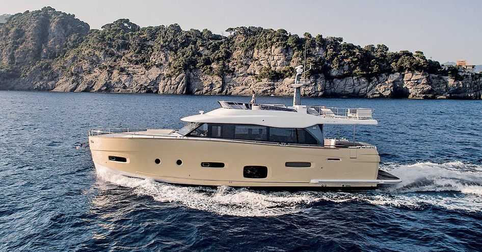 Side view of Azimut Magellano 66 underway, surrounded by sea and cliffs