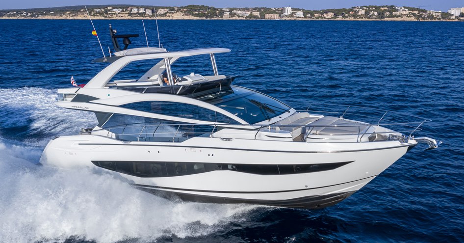 Pearl 62 flybridge yacht underway, surrounded by sea and distant cliffs