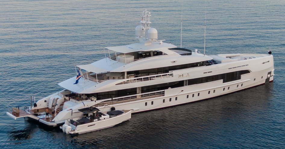 Heesen superyacht ELA at anchor in a calm sea with her tender attached to the side